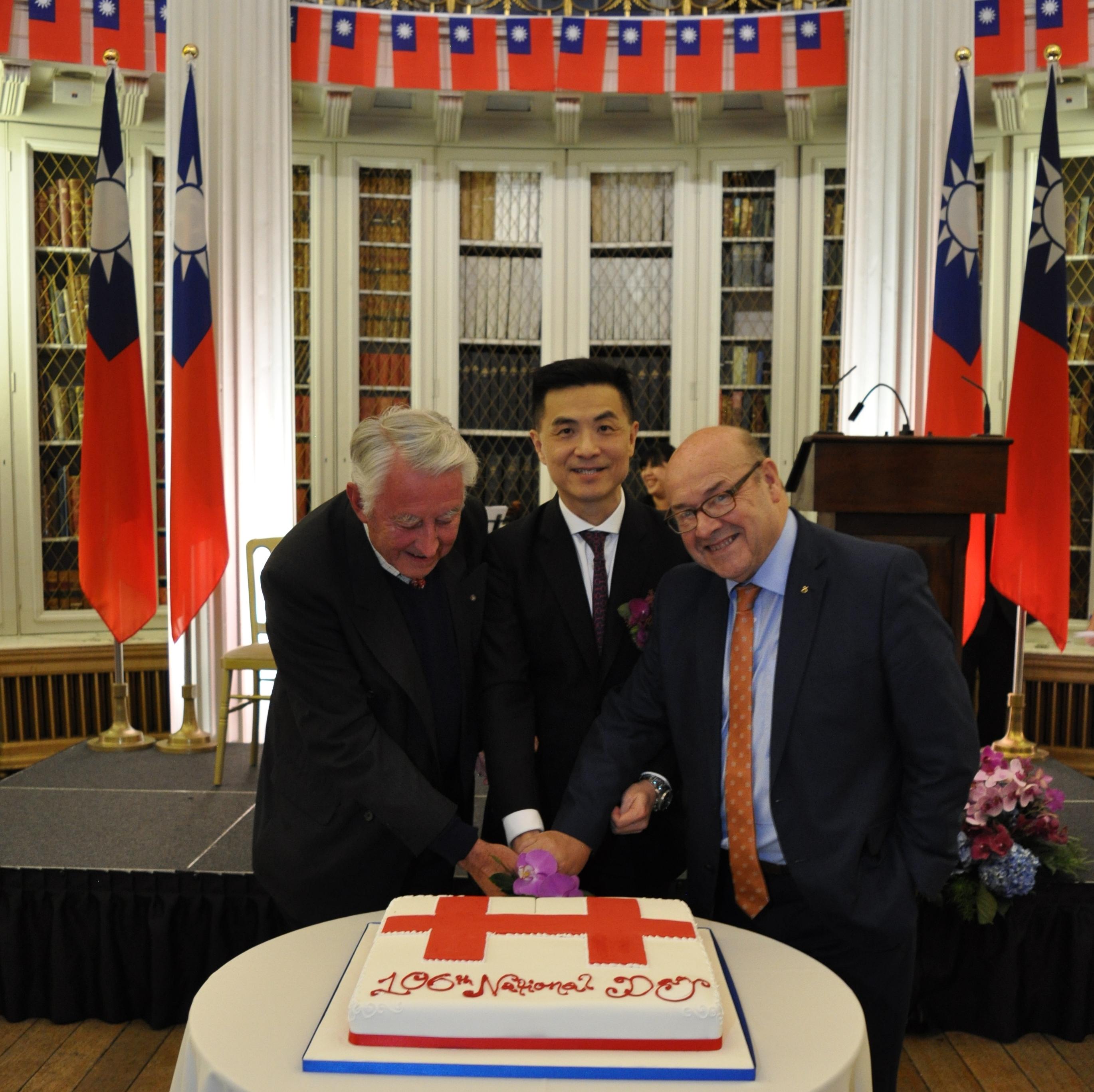 Director General Jason Lien invites Lord David Steel and MSP James Dornan to cut the birthday cake.