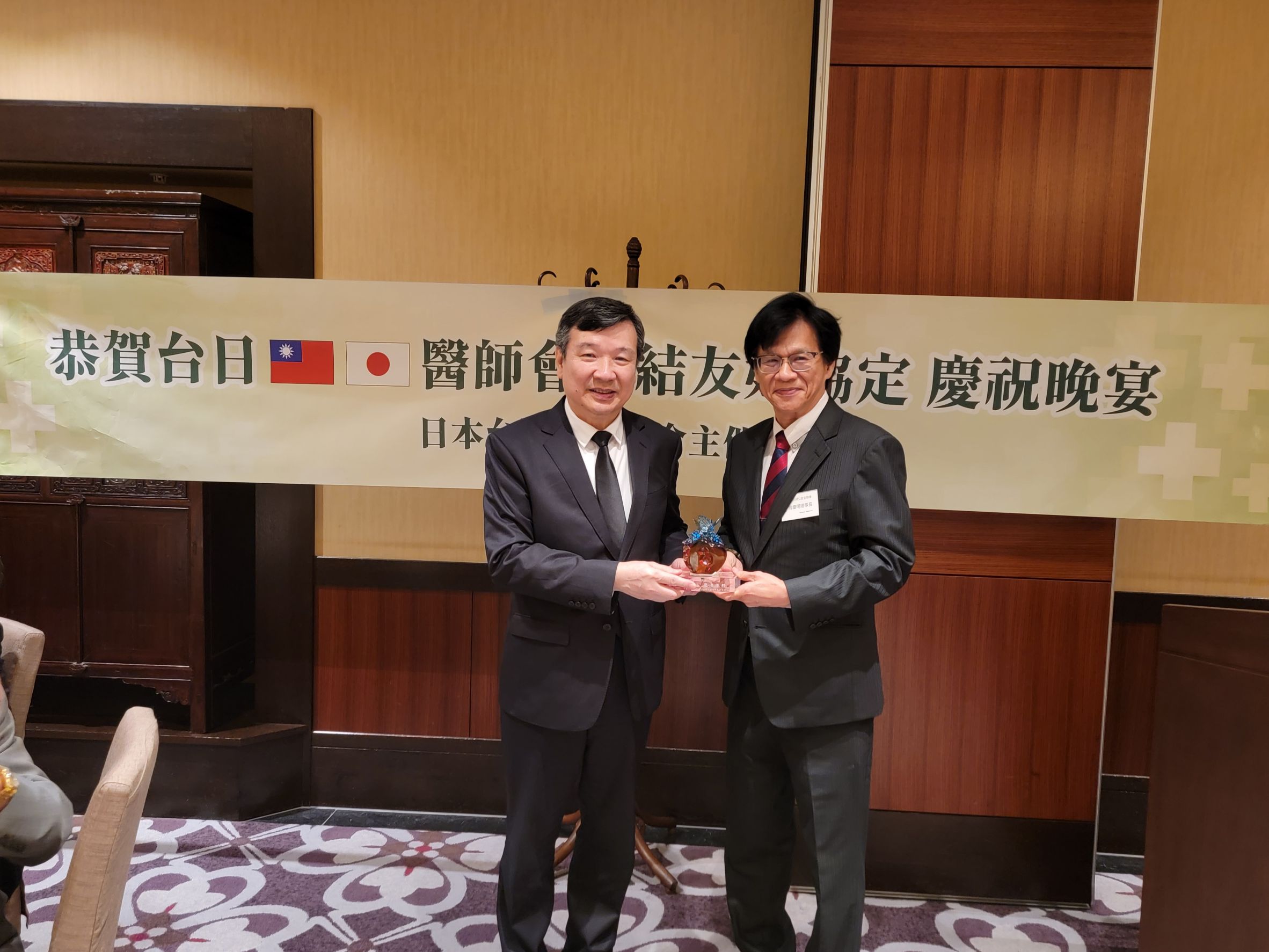 駐日代表李逸洋本(8)月9日出席由日本臺灣醫師連合主辦的「台日醫師會締結友好協定慶祝晚宴」，恭賀台日兩國醫師會80年來首次締結友好協定。李逸洋代表(左)、中華民國醫師公會全國聯合會周慶明理事長(右)