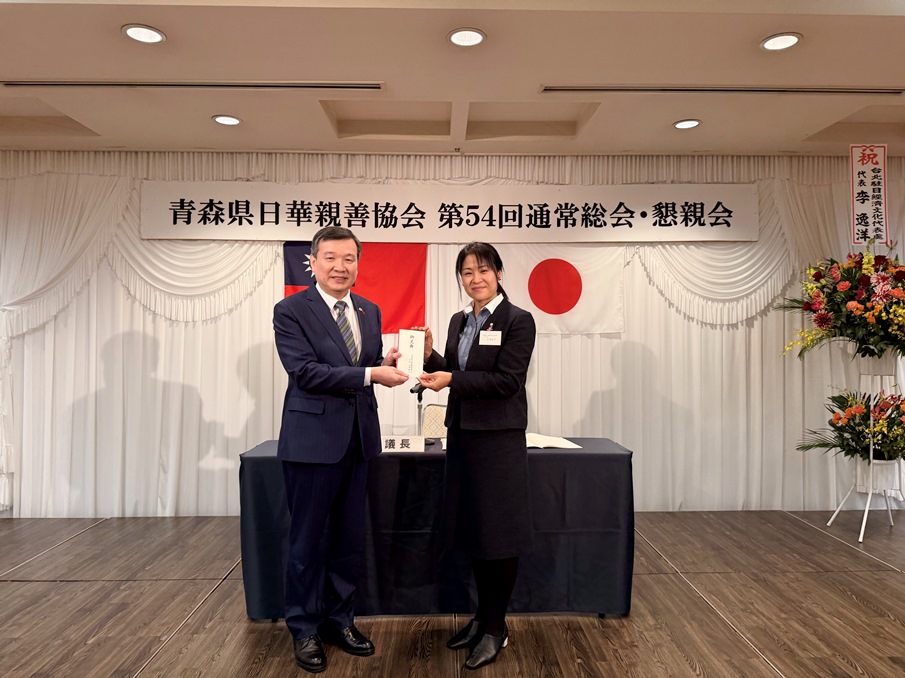 10月22日至23日駐日代表李逸洋夫婦訪問青森縣。22日晚間李大使夫婦應邀出席「青森縣日台親善會協會」第54屆總會，李大使致詞感謝該協會逾50年以來積極推動青森縣及台灣地方交流，尤其2024年募款逾800萬日圓善款捐贈我0403花蓮地震。「青森縣日台親善會協會」會長山崎結子外濱町長並代表該協會捐贈0923風災善款20萬日圓，李大使代表全體國人致謝。圖說：駐日代表李逸洋在「青森縣日台親善會協會」第54屆總會致詞