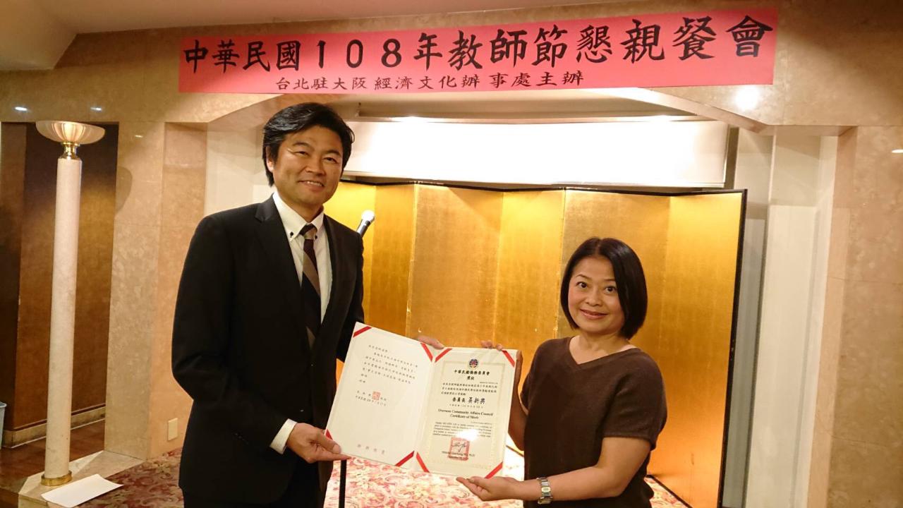 李処長（左）が中華学校の林先生にベテラン教員表彰を授与（右）